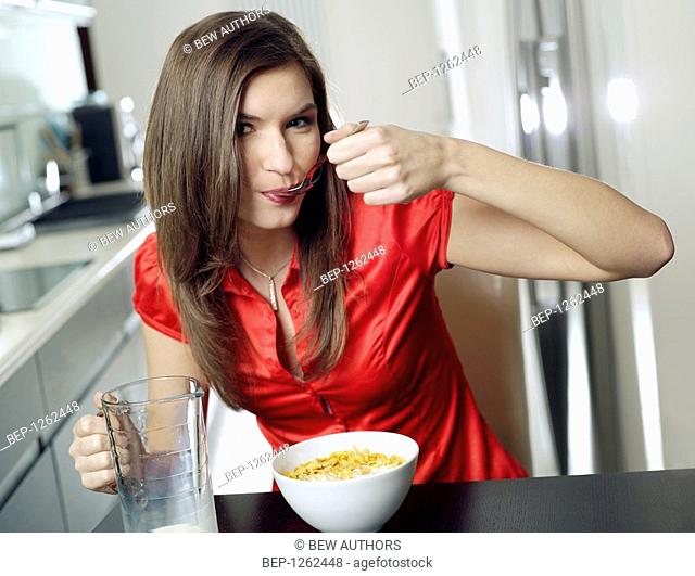 Woman eating corn flakes with milk