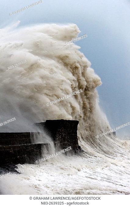 Huge waves crash against the harbour wall at Porthcawl, Bridgend, Wales, UK
