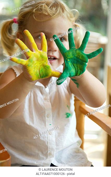 Little girl with paint on her hands