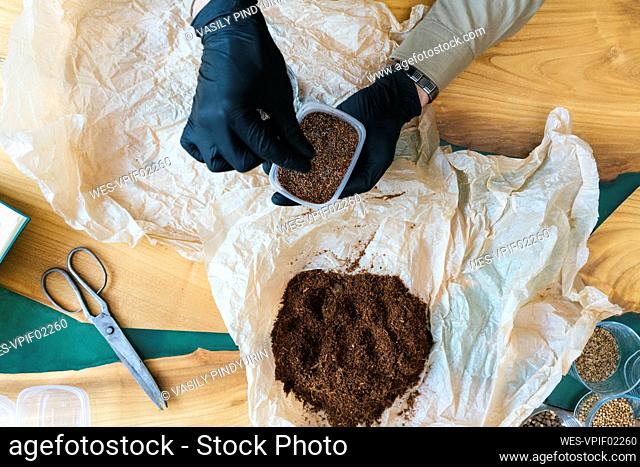 Close-up of man working on soil for microgreens