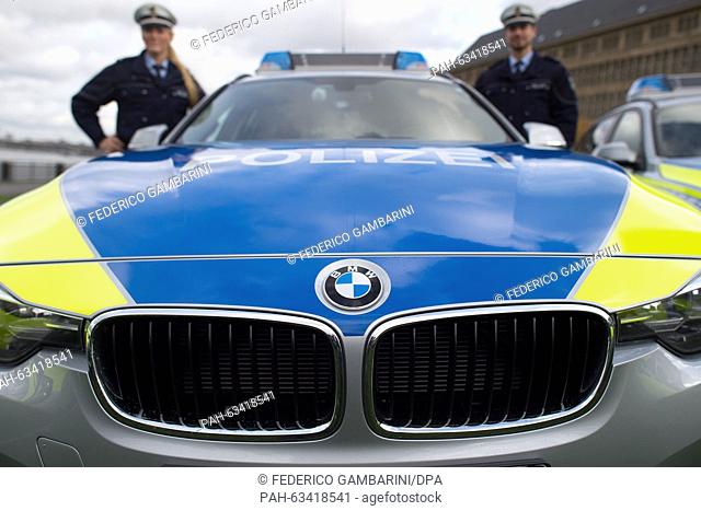 Police commissioners Josefine Klein (L) and Florian Fischer stand by their BMW 318 patrol car in Duesseldorf,  Germany, 09 November 2015