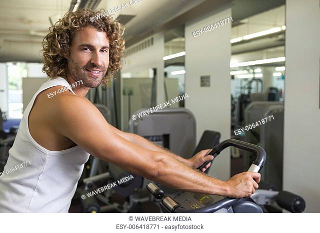 Side view portrait of man working out on exercise bike