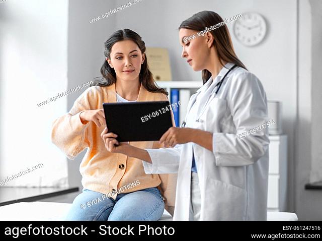 female doctor with tablet pc and woman at hospital