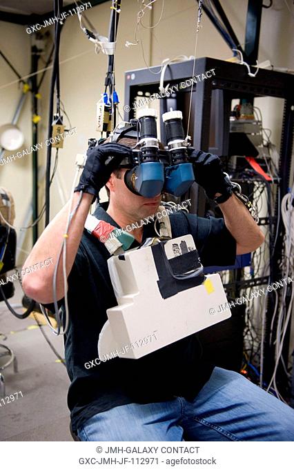 NASA astronaut Greg Chamitoff, STS-134 mission specialist, uses virtual reality hardware in the Space Vehicle Mock-up Facility at NASA's Johnson Space Center to...