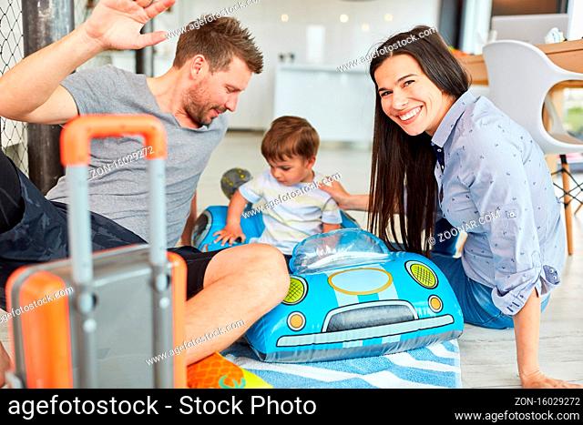 Eltern spielen mit Kleinkind im aufblasbaren Rennauto im Wohnzimmer