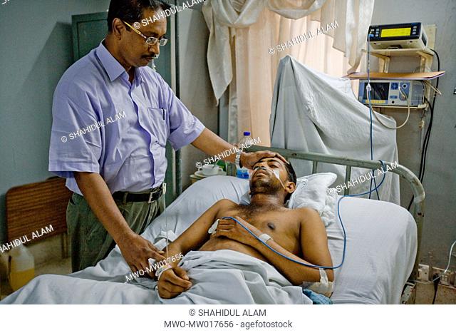 In the ICU of Chittagong Medical Hospital, Dr Kamal attends to Jahangir Alam, a ship breaking worker, seriously injured by an accident at work