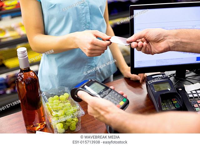 Woman at cash register paying with credit card