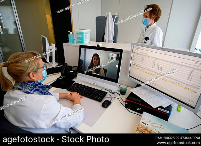 25 March 2020, North Rhine-Westphalia, Aachen: The anaesthetists Anke Offermann (l) and Sandra Dohmen sit and stand in a workroom of the ""virtual hospital...