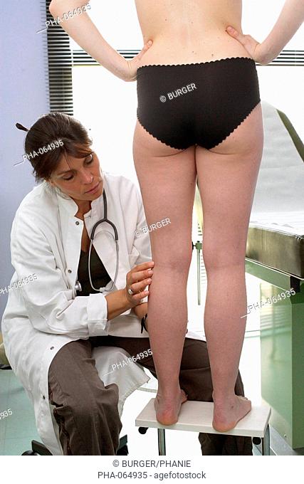 Phlebologist examining the legs of a female patient