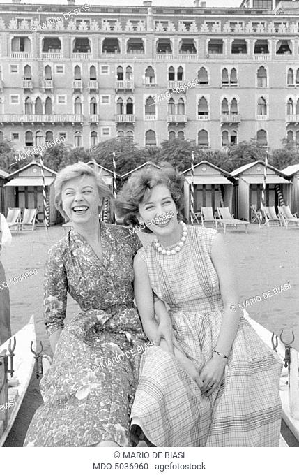 Italian actresses Giulietta Masina and Valentina Cortese smiling on the beach during the XVIII Venice International Film Festival. Venice, 1957