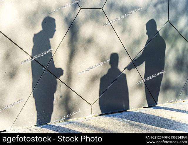 07 December 2022, Hessen, Frankfurt/Main: The shadow cast by three people stands on the outer facade of the DFB headquarters