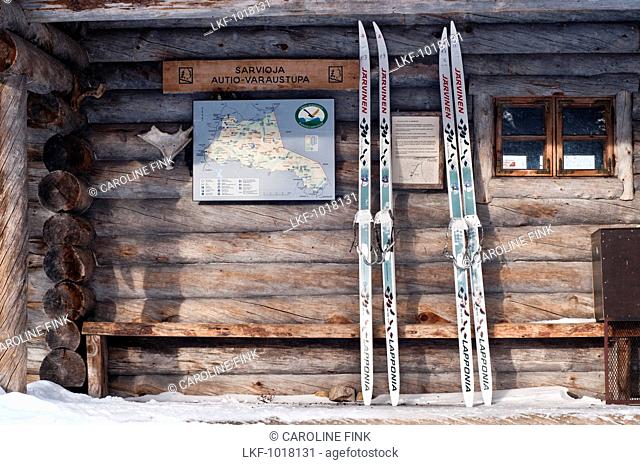Two pairs of finnish backcountry skis, so called Metsasukset, leaning against the wooden front of the Sarvioja Hut, Urho Kekkonen National Park, finnish Lapland
