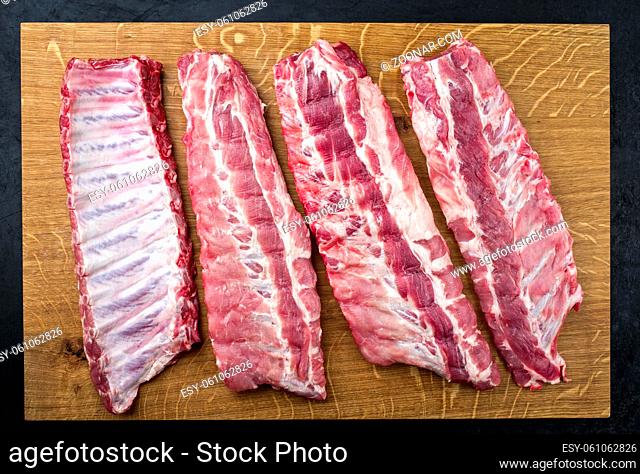 Raw pork spare loin ribs St Louis cut offered as top view on a wooden board