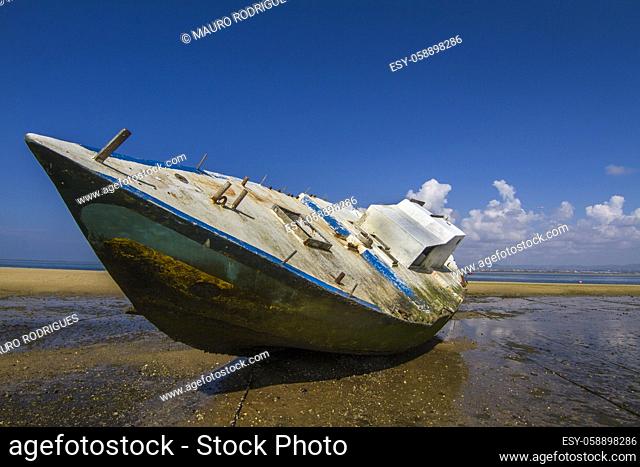 View of an old abandoned boat stranded on dry sand at the beach
