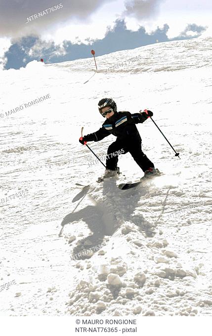 A skiing boy in the snow, Italy
