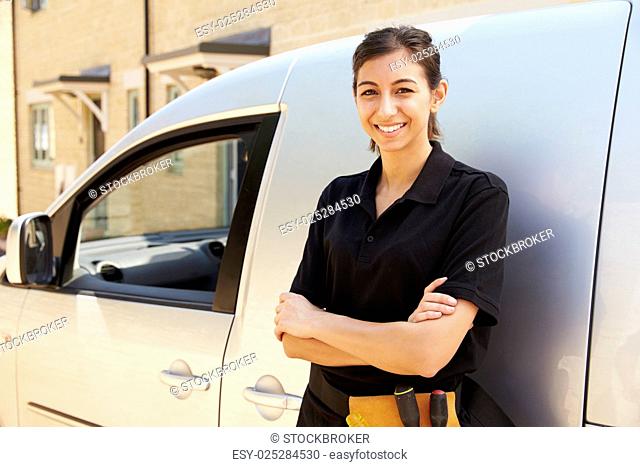 Portrait of young female trade worker standing by a van