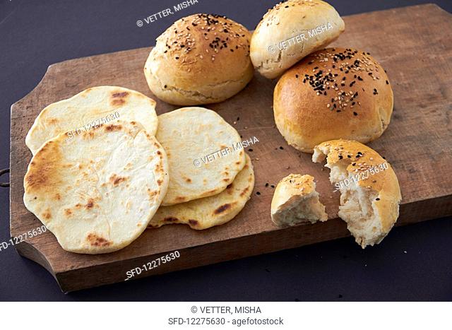 Burger buns and flatbread on a wooden board
