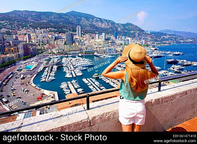 Aerial view of beautiful girl in Monte-Carlo looking cityscape with skyscrapers and harbor in Monaco City-State