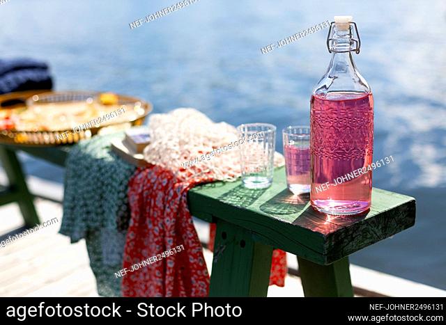 Bottle and glasses on bench