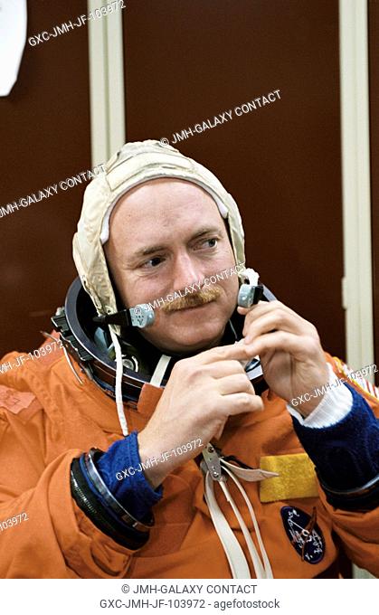 Astronaut Mark E. Kelly, STS-108 pilot, dons a training version of the full-pressure launch and entry suit prior to a training session in one of the...