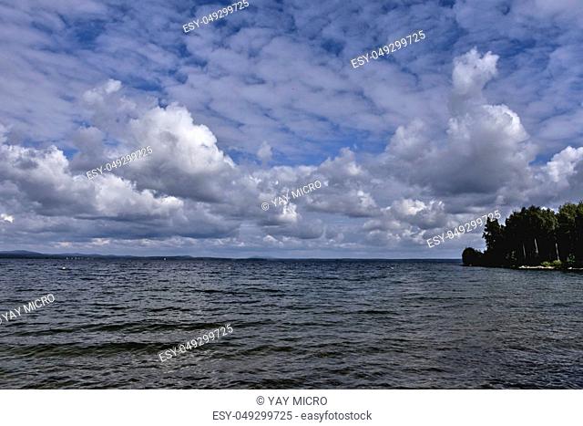 blue sky with powerful cumulonimbus clouds over the lake