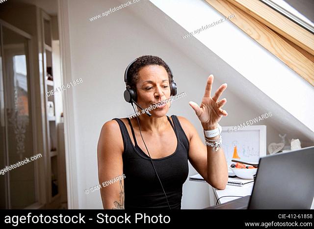 Woman in headset working from home at laptop