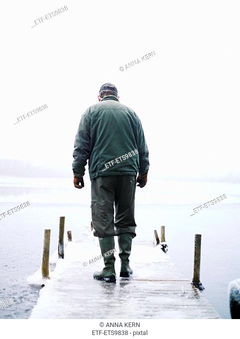 An old man walking on a jetty Sweden