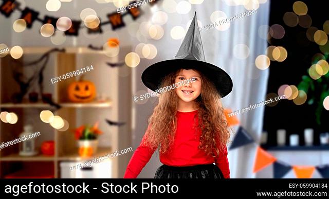 happy girl in black witch hat on halloween