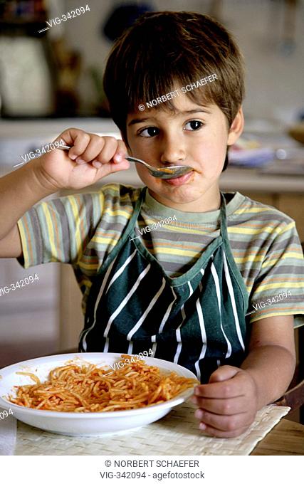 Boy eats spaghetti in the kitchen. - MAJORCA, SPAIN, 14/12/2006