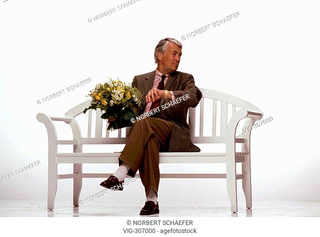 Older man sitting on a bench with a bunch of flowers. - 25/10/2006