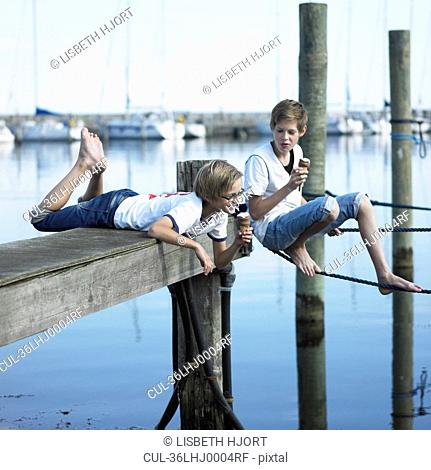 Boys eating ice cream on pier