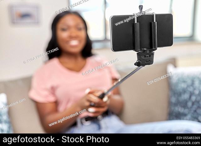 happy african american woman taking selfie at home