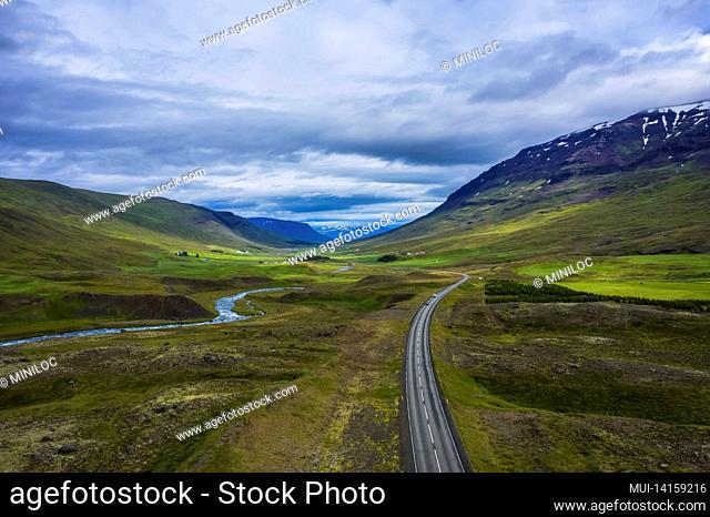 aerial scenic landscape of iceland. remote road and small bridge over blue mountain river. travel vacation and advanture concept