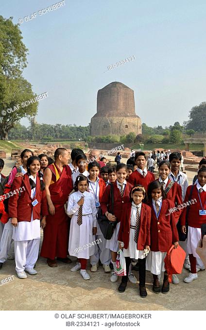 Pupils of an Indian school class, boys and girls, with Tibetan monks and a Rinpoche visiting the Dhamekh Stupa, Game Park of Isipatana, Sarnath, Uttar Pradesh