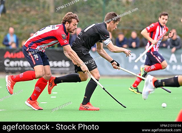 Leopolds's Maxime Plennevaux and Racing's Jerome Truyens fight for the ball during a hockey game between Royal Racing Club and Royal Leopold Club