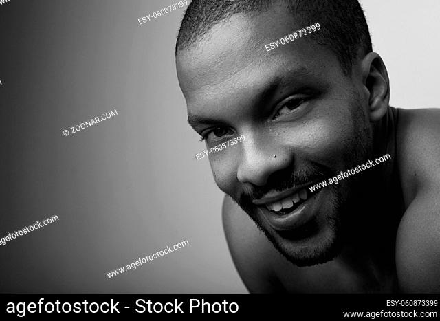 Portrait of cheerful bearded black man over light background. Black and white. High quality photo