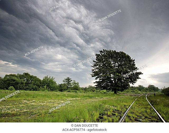 Dramatic clouds mark the leading edge of a lightning storm as it moves over train tracks in Windsor Junction, Nova Scotia, Canada