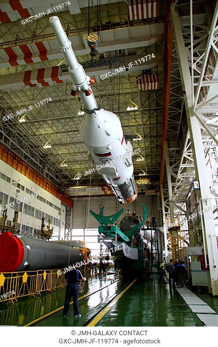 At the Baikonur Cosmodrome in Kazakhstan, technicians hoist the upper stage of the Soyuz TMA-16 rocket in its integration facility for mating to its first stage...