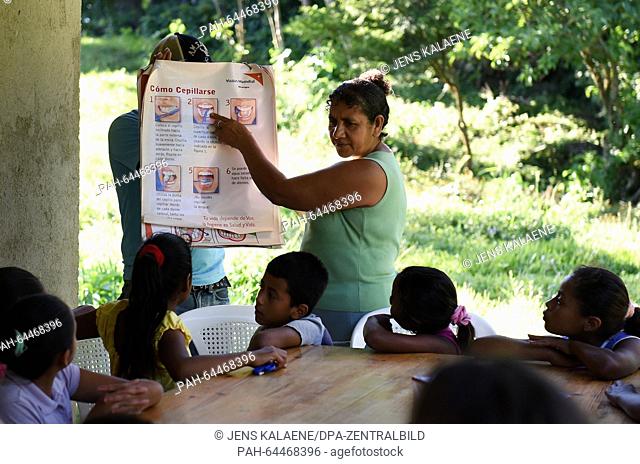 A teacher shows children in a leisure camp on a poster of the humanitarian aid organisation World Vision how to brush teeth correctly in Limay La Fraternidad