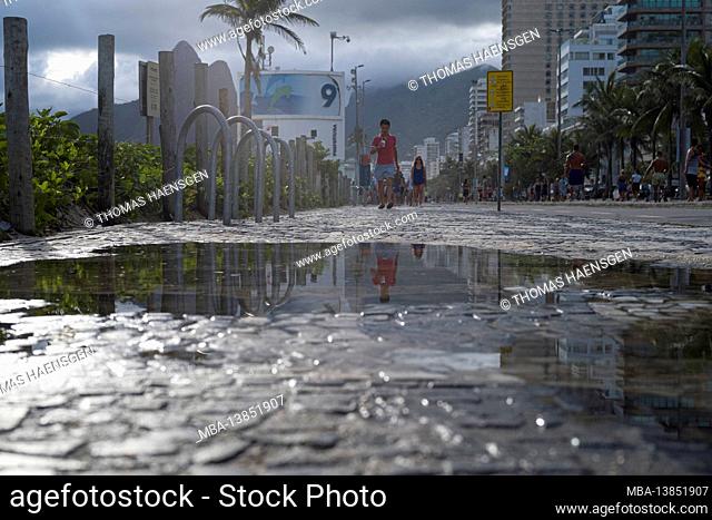 Big Puddle of water after rain reflecting Two Brothers Mountain (Dois Irmaos) at the sidewalk near beach of Ipanema/Leblon in Rio de Janeiro, Brazil