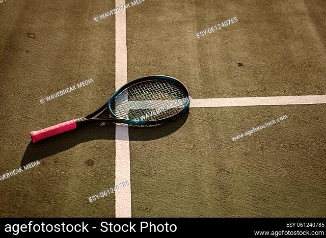 High angle view of tennis racket on white lines at tennis court during sunset, copy space