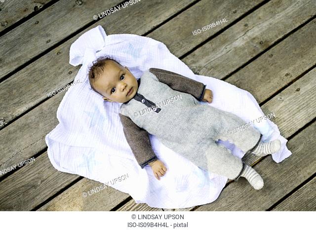 Portrait of baby boy lying on blanket, overhead view