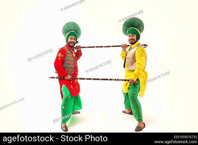 Two Bhangra dancers performing a dance step together using Khunda