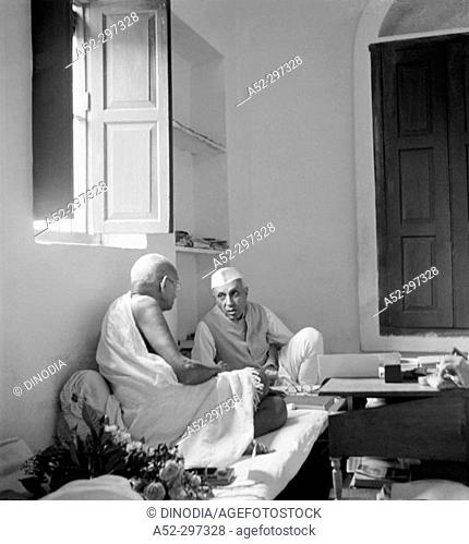 Gandhi talking with co-worker Jawaharlal Nehru at Bhangi (Sweeper's) colony on his 77th birthday. New Delhi. India. October 2, 1946