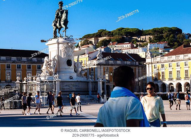 Tourists walking by statue of King José I in ""Praca do Comercio"" square