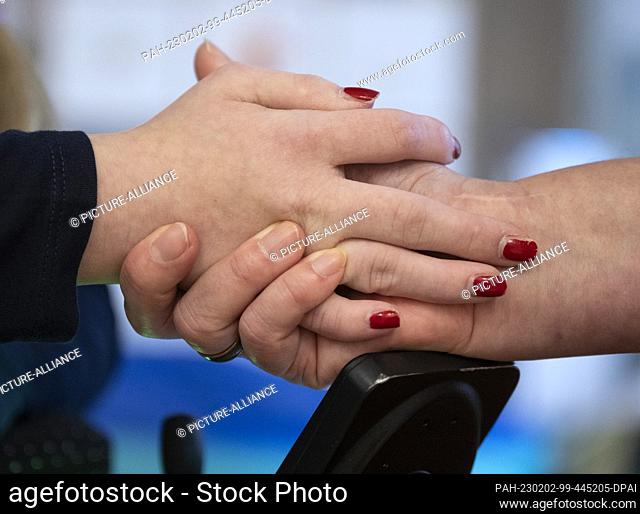 PRODUCTION - 11 January 2023, Hesse, Wiesbaden: In the living area of the ""Bärenherz"" children's hospice, Jeanette Ott (r) holds the hand of her daughter...