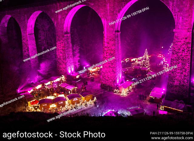 dpatop - 26 November 2021, Baden-Wuerttemberg, Breitnau: People stand between stalls at the Ravenna Gorge Christmas market, which takes place under an aqueduct
