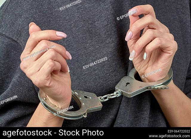 women's hands are handcuffed in close-up. High quality photo