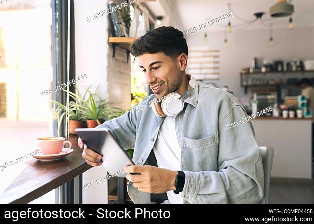 Young businessman using tablet PC in coffee shop