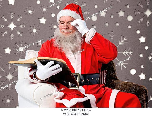 Santa claus reading a book while sitting on a chair